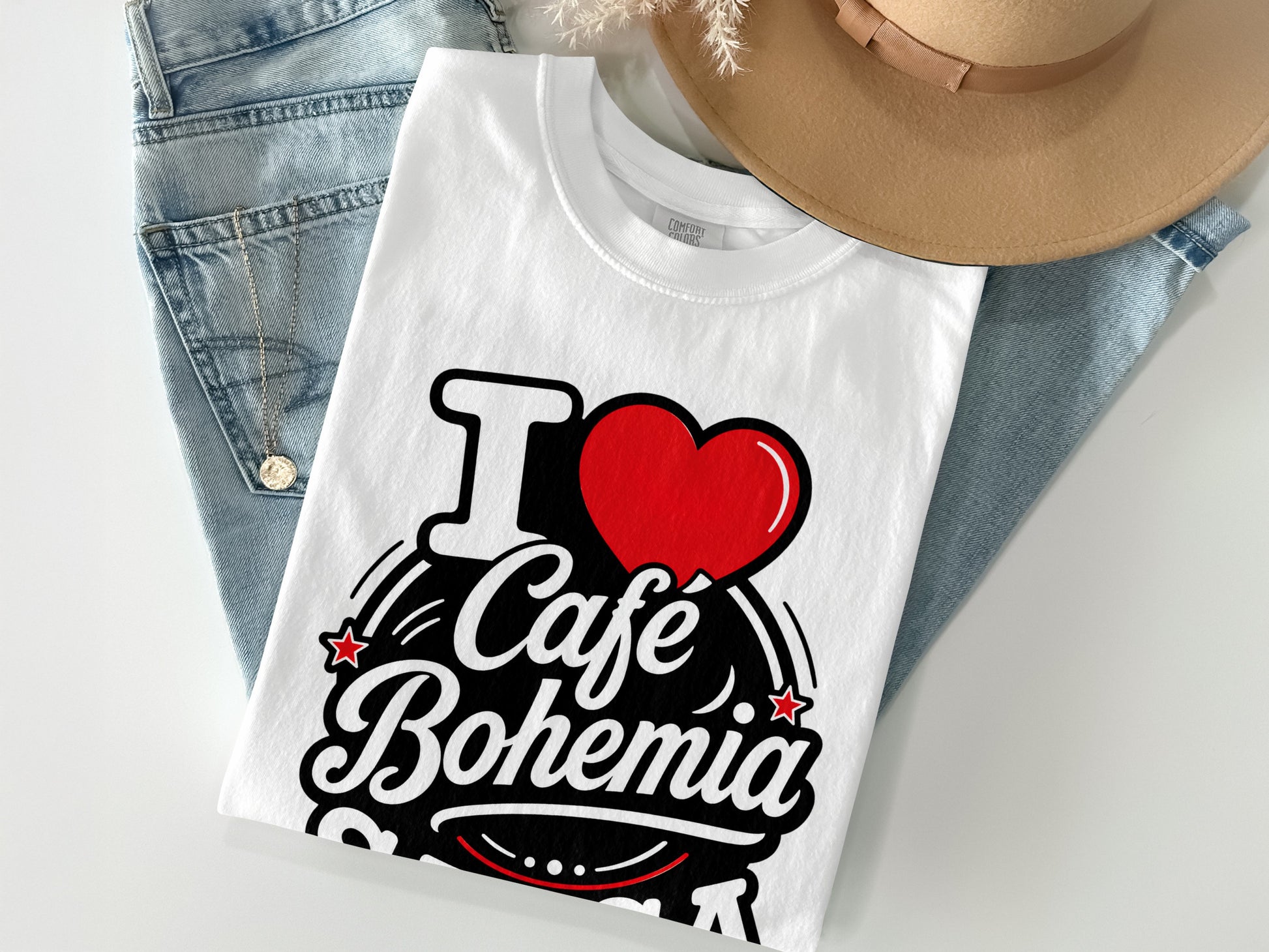 White t-shirt with "I ❤️ Cafe Bohemia" text and a hat and jeans.